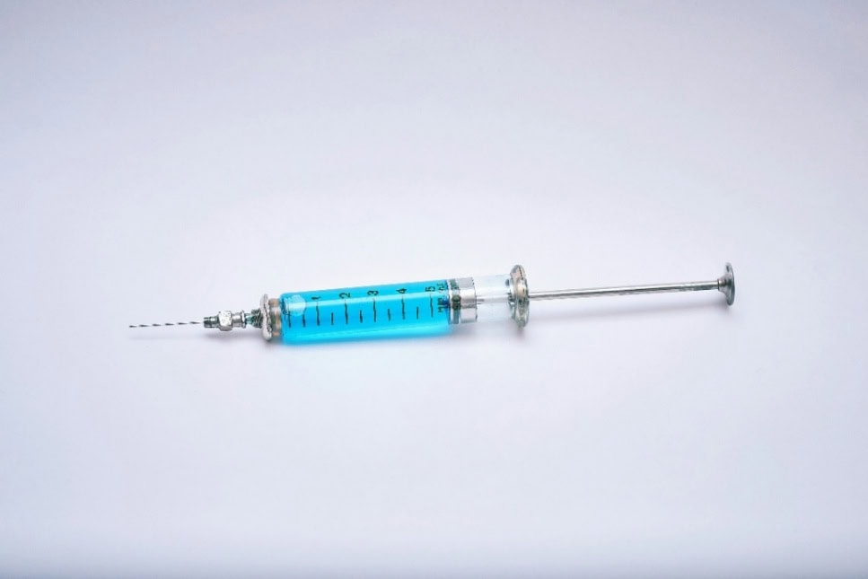 A needly and syringe filled with blue fluid
